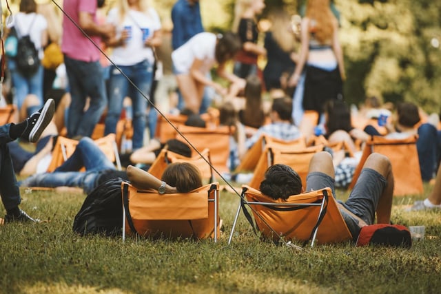 people at festival sat on deck chairs