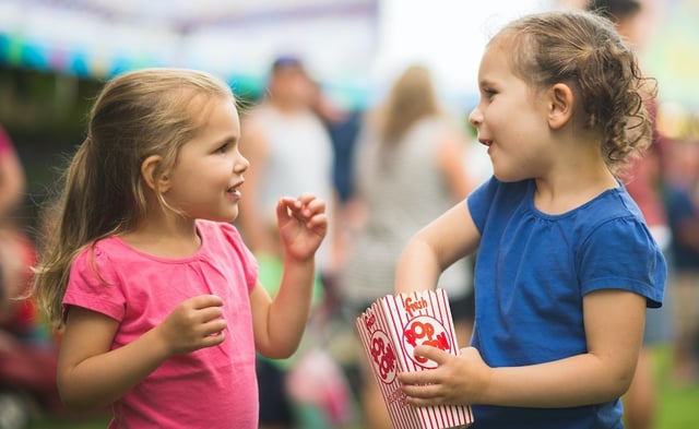 kids sharing popcorn at a festival cropped